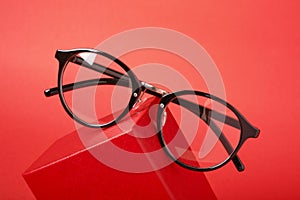 Eye glasses on red gift box red background