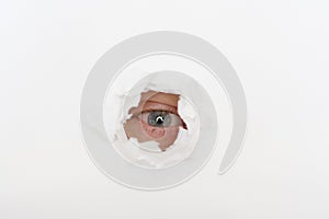 Eye in the hole of white paper