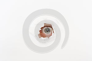Eye in the hole of white paper