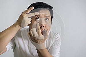 Eye irritation concept. Portrait of Asian man in posture of eye tired