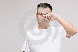 Eye irritation concept : Portrait of Asian man in posture of eye tired,  irritation or problem about his eye. Studio shot isolated