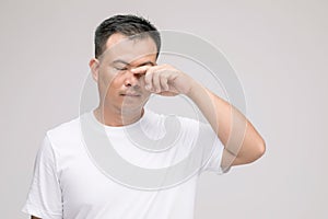 Eye irritation concept : Portrait of Asian man in posture of eye tired,  irritation or problem about his eye. Studio shot isolated