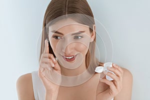 Eye lens. Smiling woman with contact eye lenses and container