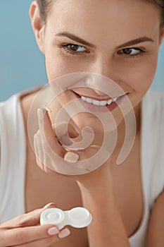 Eye lens. Smiling woman with contact eye lenses and container