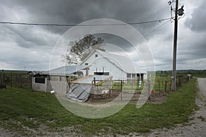 Eye-level gloomy shot of an old white barn on a cloudy day