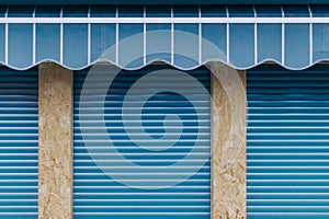 Eye-level shot of a closed store with blue sunblind and shutters