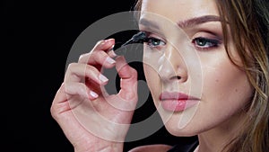 Eye makeup. Beautiful woman applying mascara on lashes