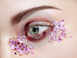 Eye makeup woman with a lilac flowers