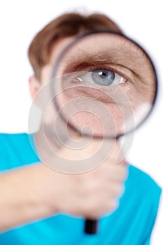 Eye of man, looking through magnifying glass