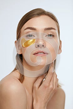 Eye patch. Woman with gold under eye pads on beauty face