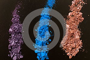 Eye shadows on black background. Crushed cosmetic. Make up cosmetics. Top view and mock up