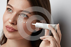 Eye Skin Care. Beautiful Woman Applying Eye Cream
