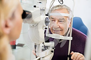 Eye specialist determines distance of eyes pupil to patient