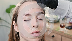 Eyebrow artist outlines client eyebrow to make shape