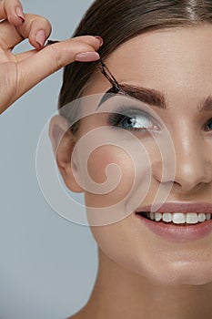 Eyebrow cosmetics. Woman taking off brow gel tint from eyebrow