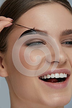 Eyebrow cosmetics. Woman taking off brow gel tint from eyebrow