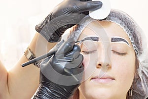 Eyebrow dyeing. beauty saloon. the girl lies with her eyes closed on the eyebrow dyeing procedure.