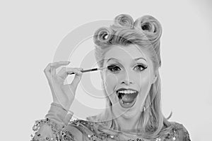 Eyebrow makeup. Blonde excited woman brushing brows with brows brush closeup. Pin up style.