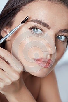 Eyebrow Makeup. Woman Brushing Brows With Brush. Beautiful Girl With Blue Eyes And Perfect Skin