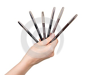Eyebrow pencils in female hand isolated on white background.