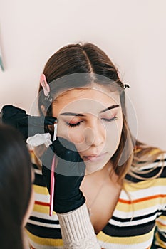 Eyebrow shaping procedure, make-up master uses brush to shape the eyebrows