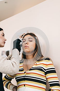 Eyebrow shaping procedure, make-up master uses brush to shape the eyebrows