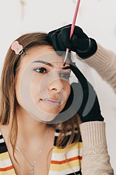 Eyebrow shaping procedure, make-up master uses brush to shape the eyebrows