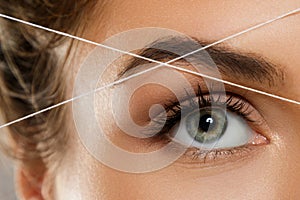 Eyebrow threading - epilation procedure for brow shape correction