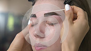 Eyebrow tinting. Close-up of a master applying eyebrow dye with a brush. Cosmetic procedures, permanent eyebrow makeup