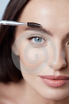 Eyebrows. Beautiful Woman Brushing Brows With Brush. Blue-Eyed Girl Close Up Portrait. Female With Perfect Skin.