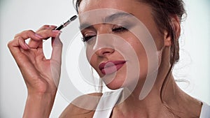 Eyebrows Makeup. Woman combing eyebrow with brush closeup