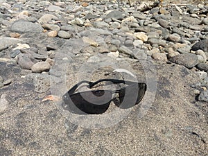 eyeglass lenses on river sand photo