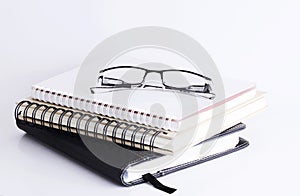 Eyeglass on top books stack Isolated on white background
