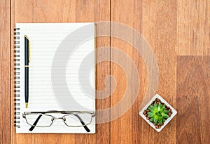 Eyeglasse and notepad on wood deck with copyspace