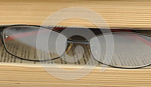 Eyeglasses on the betwixt pages old book.