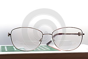 Eyeglasses with bifocal lenses on a book
