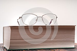 Eyeglasses with bifocal lenses on book