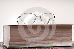 Eyeglasses with bifocal lenses on book photo