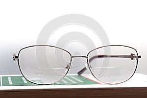 Eyeglasses with bifocal lenses on a book photo