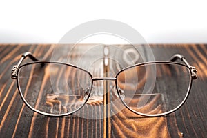 Eyeglasses with bifocals lenses on wooden board photo