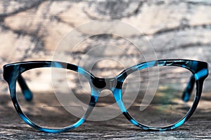 Eyeglasses Glasses with Bifocals and Black Blue Frame smudged  Fashion Vintage Style on Wood Desk Background, Rustic Still Life