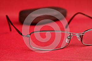 Eyeglasses and glasses case on red background