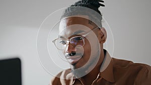 Eyeglasses guy working laptop home closeup. Positive freelancer typing learning