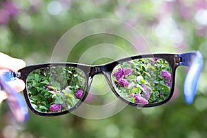 Eyeglasses in the hand over blurred background