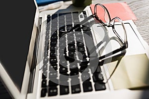 Eyeglasses on laptop computer at table