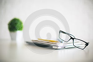 Eyeglasses, laptop, notepads and plant