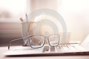 Eyeglasses on laptop in sunlight