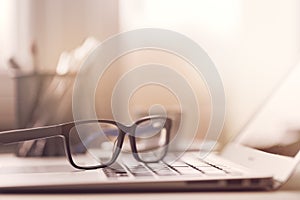 Eyeglasses on laptop in sunlight