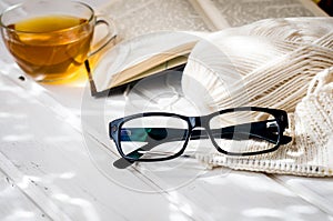 Eyeglasses, open book, Cup of tea and Knitting threads