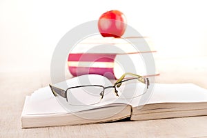 Eyeglasses on open book on table photo